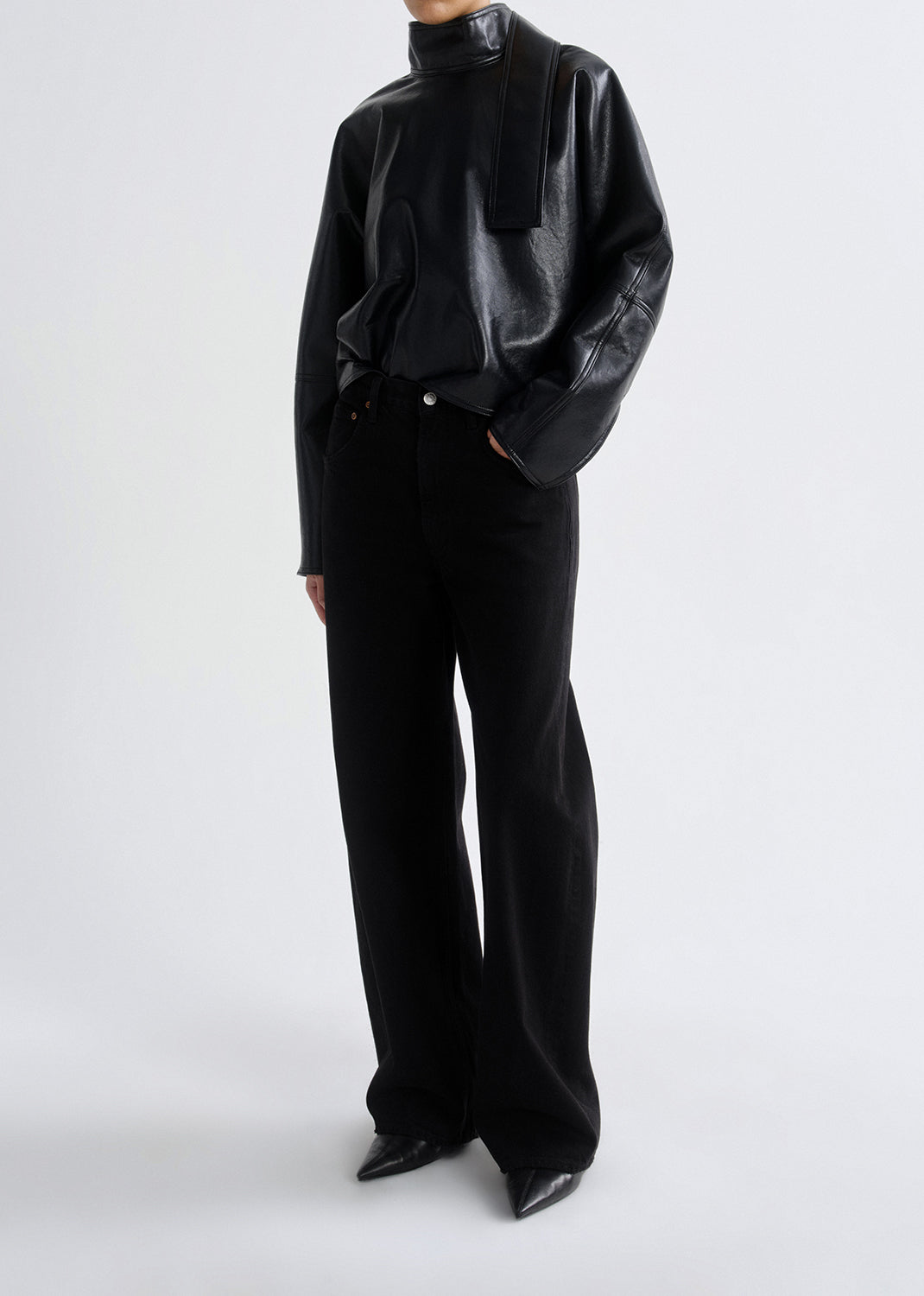Person wearing a black leather outfit on a grey background