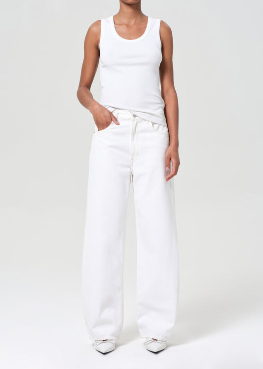 Person wearing a white tank top and white pants on a plain background