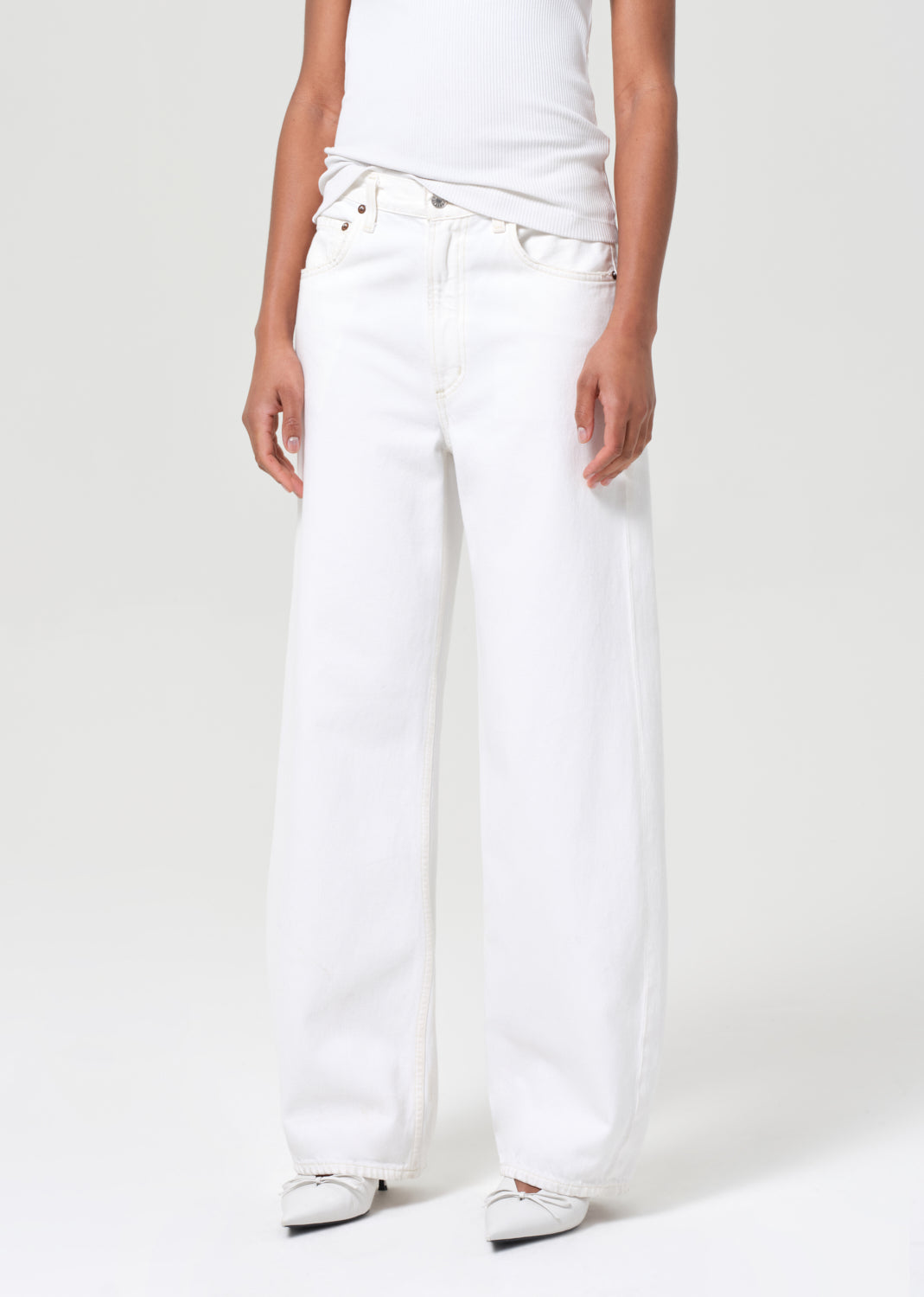 Person wearing white jeans and a white shirt on a white background