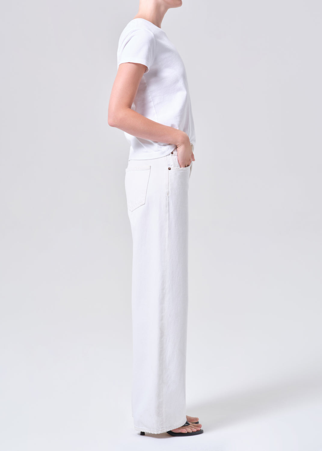 Person wearing a white t-shirt and pants on a plain background