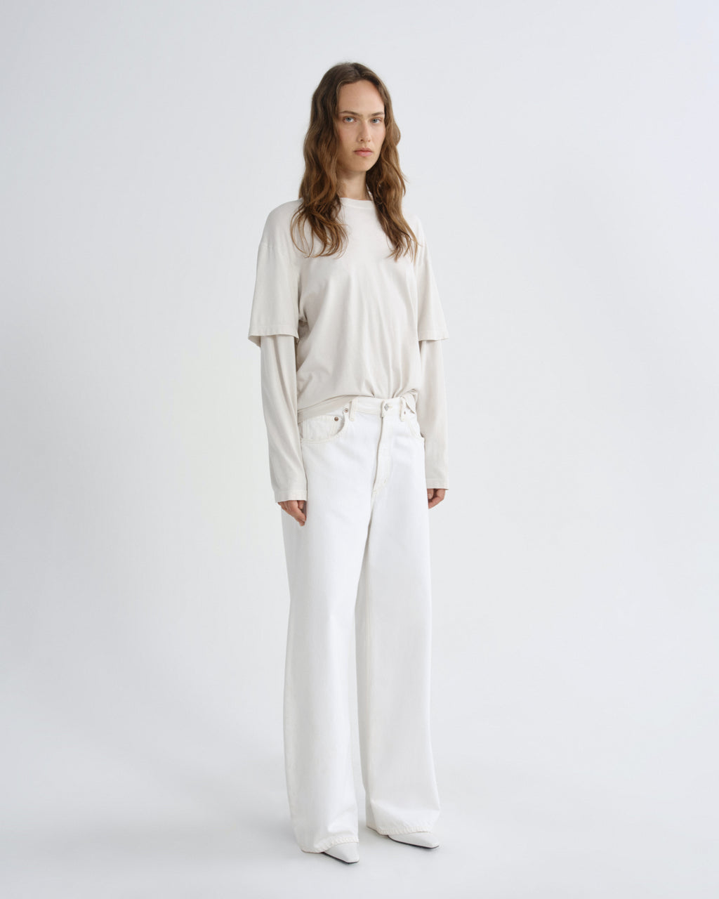 Woman wearing a white outfit on a plain background