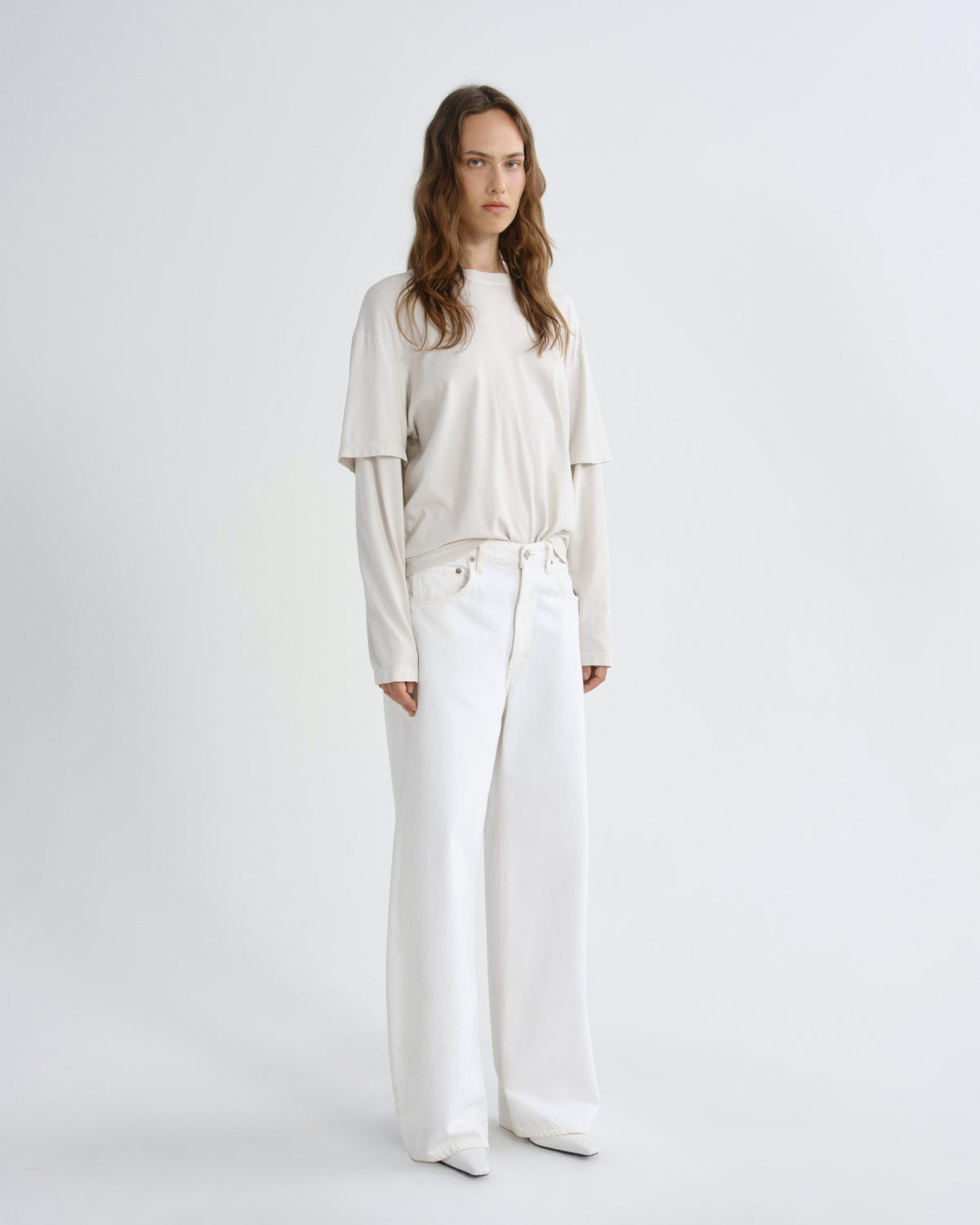 Woman wearing a white outfit on a plain background