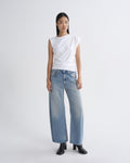 Woman wearing a white top and light blue jeans on a white background