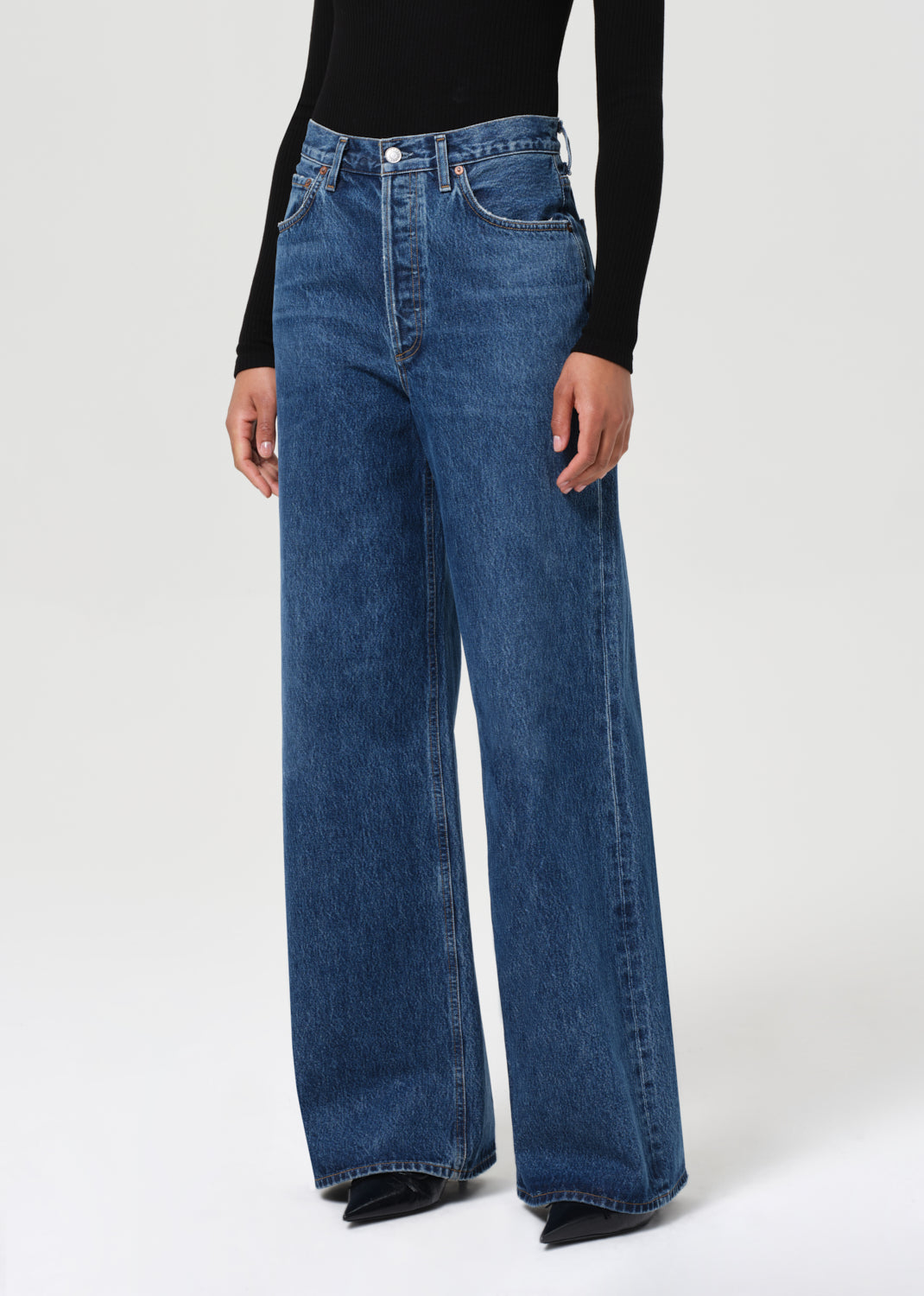 Person wearing blue jeans on a white background