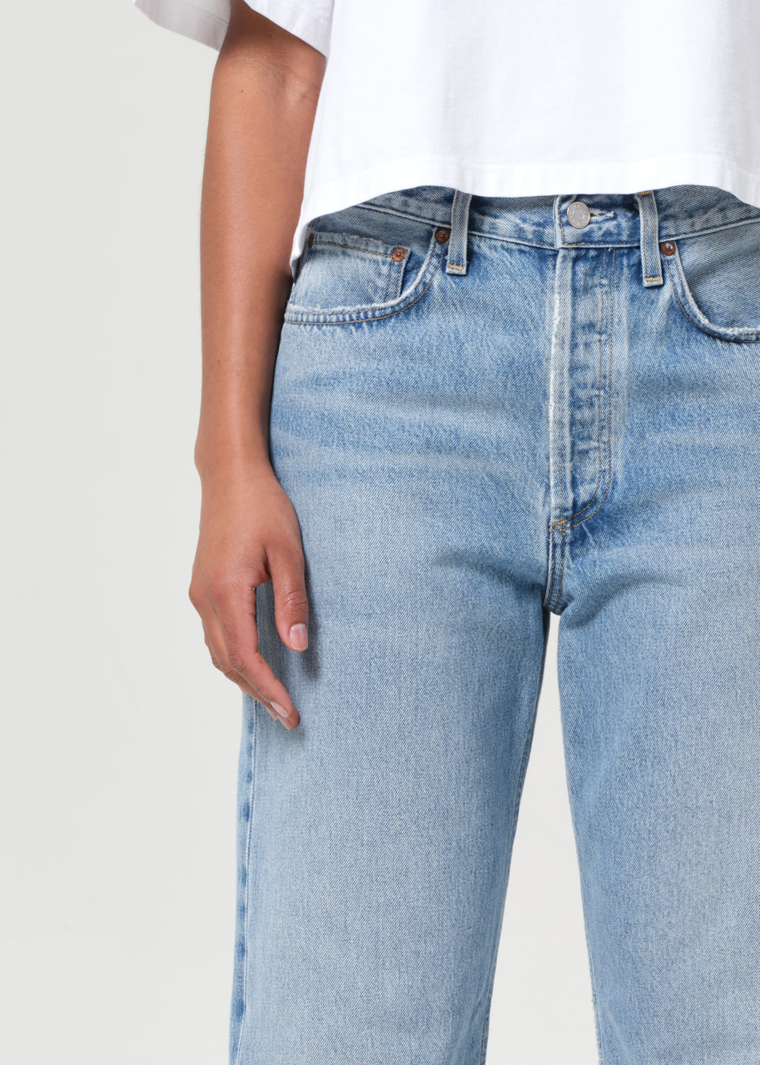 Light blue jeans worn by a person on a white background