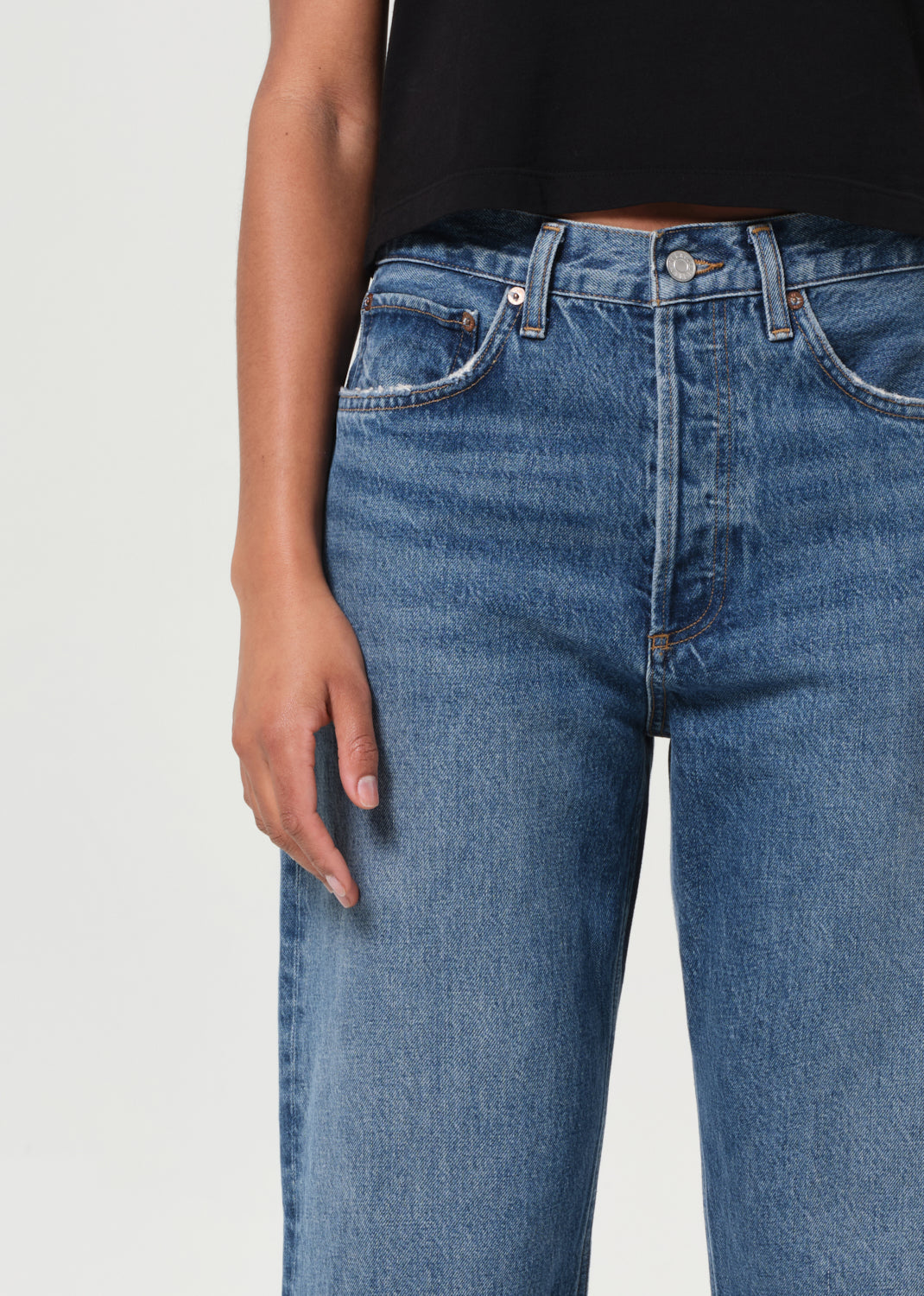 Blue jeans worn by a person on a light gray background