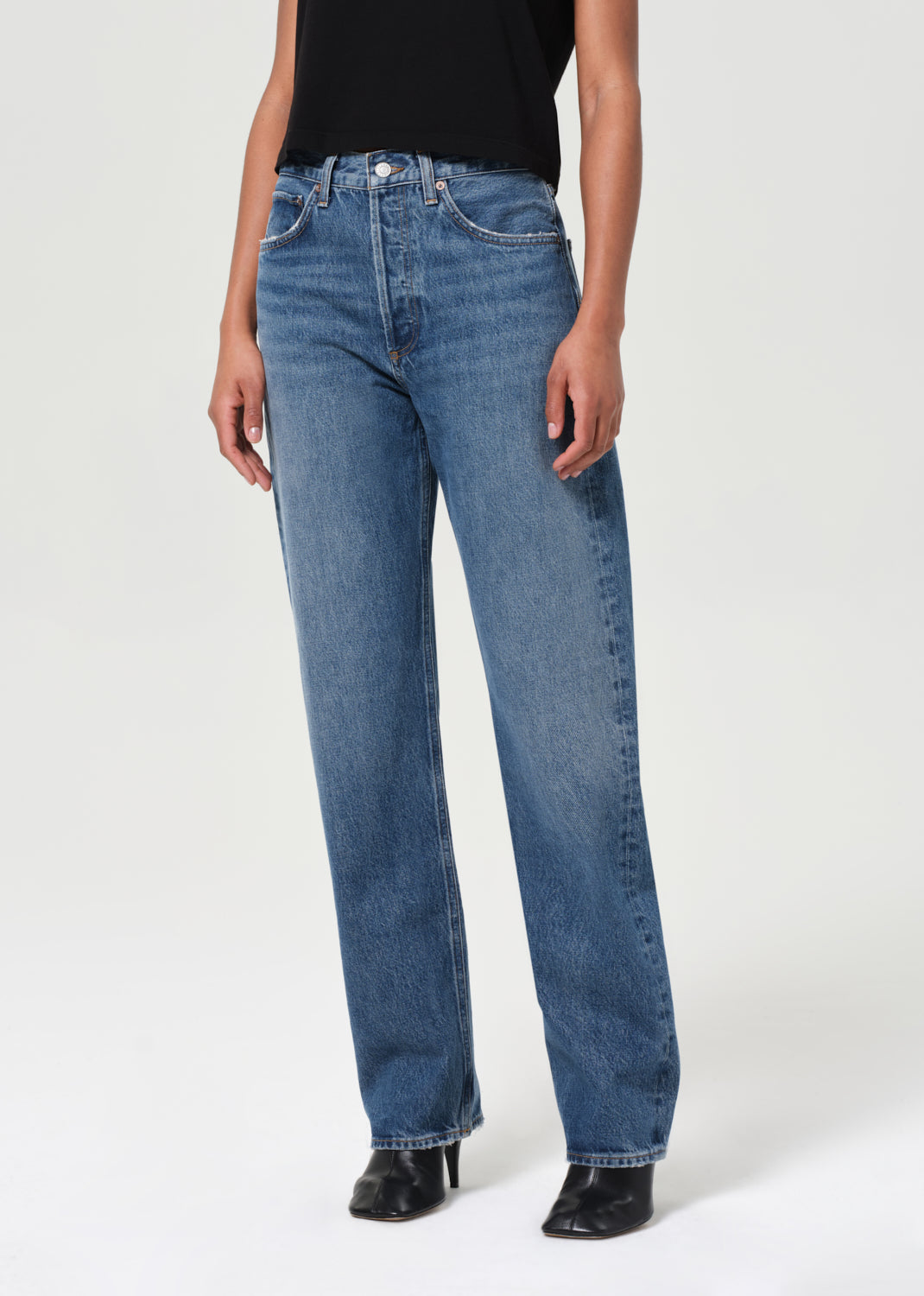 Person wearing blue jeans on a white background