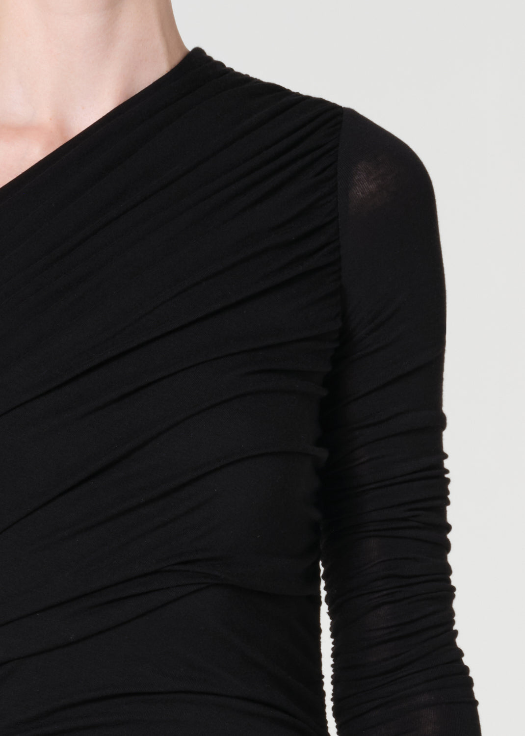 Black long-sleeve top with ruched design on a plain background