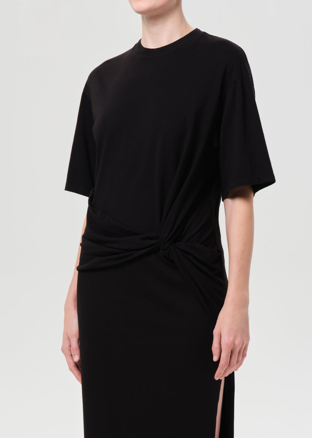 Black dress with a knot detail on a plain background