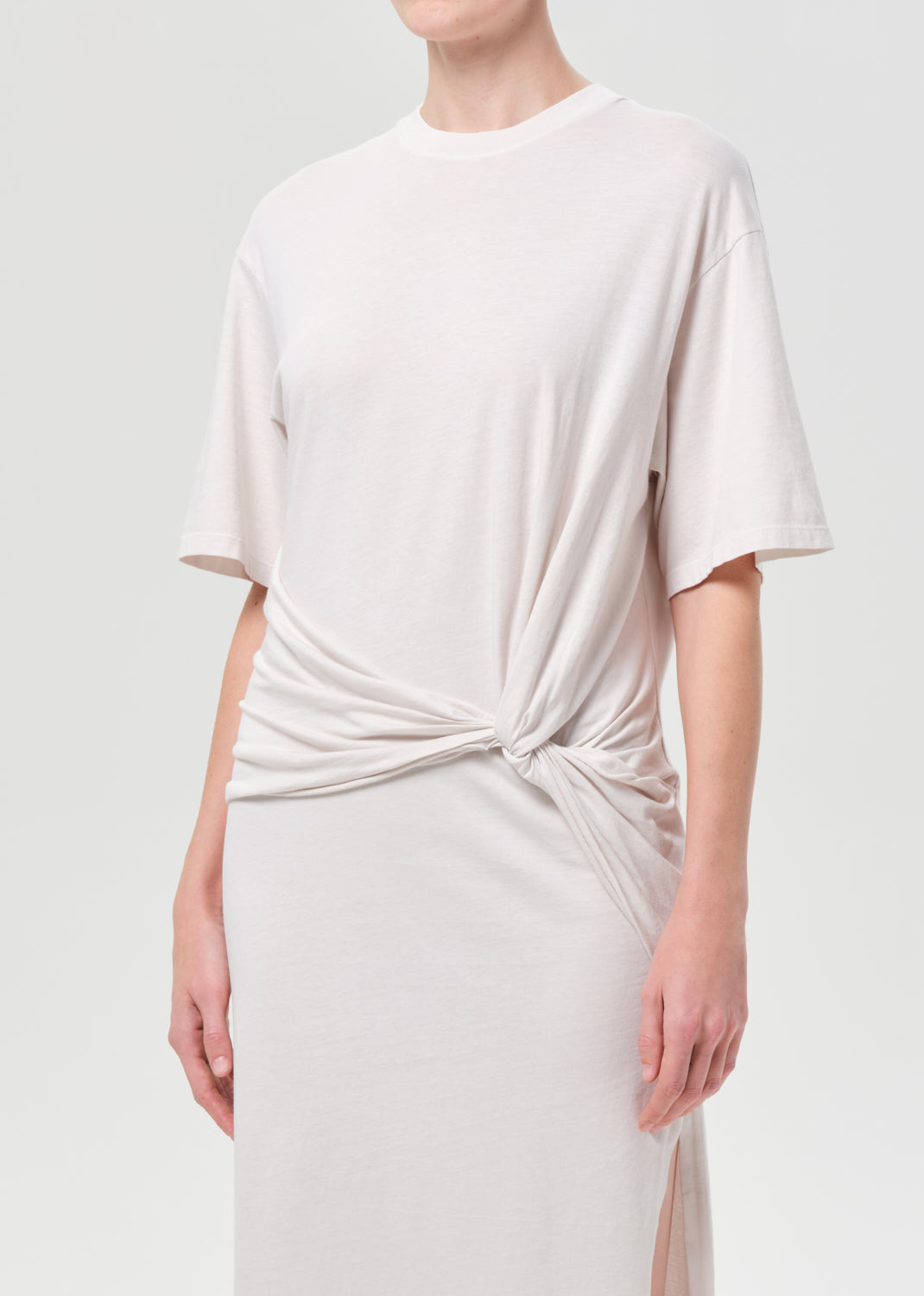 White dress with a knot detail on a plain background