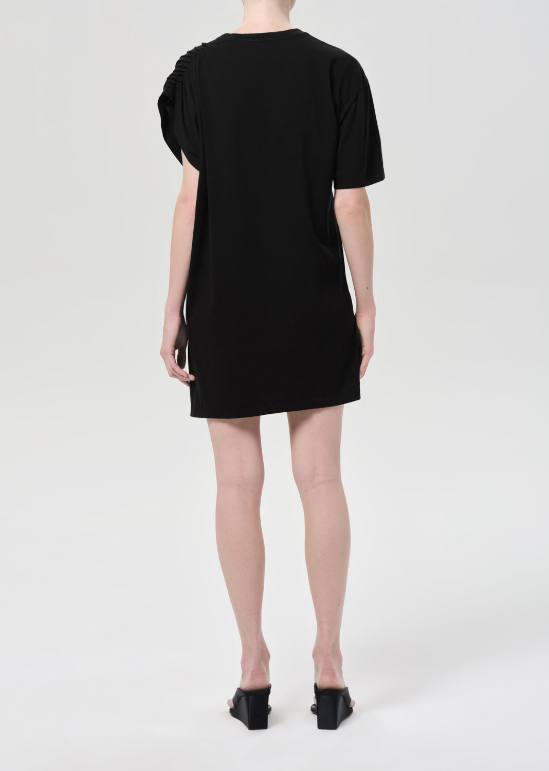 Person wearing a black dress on a white background