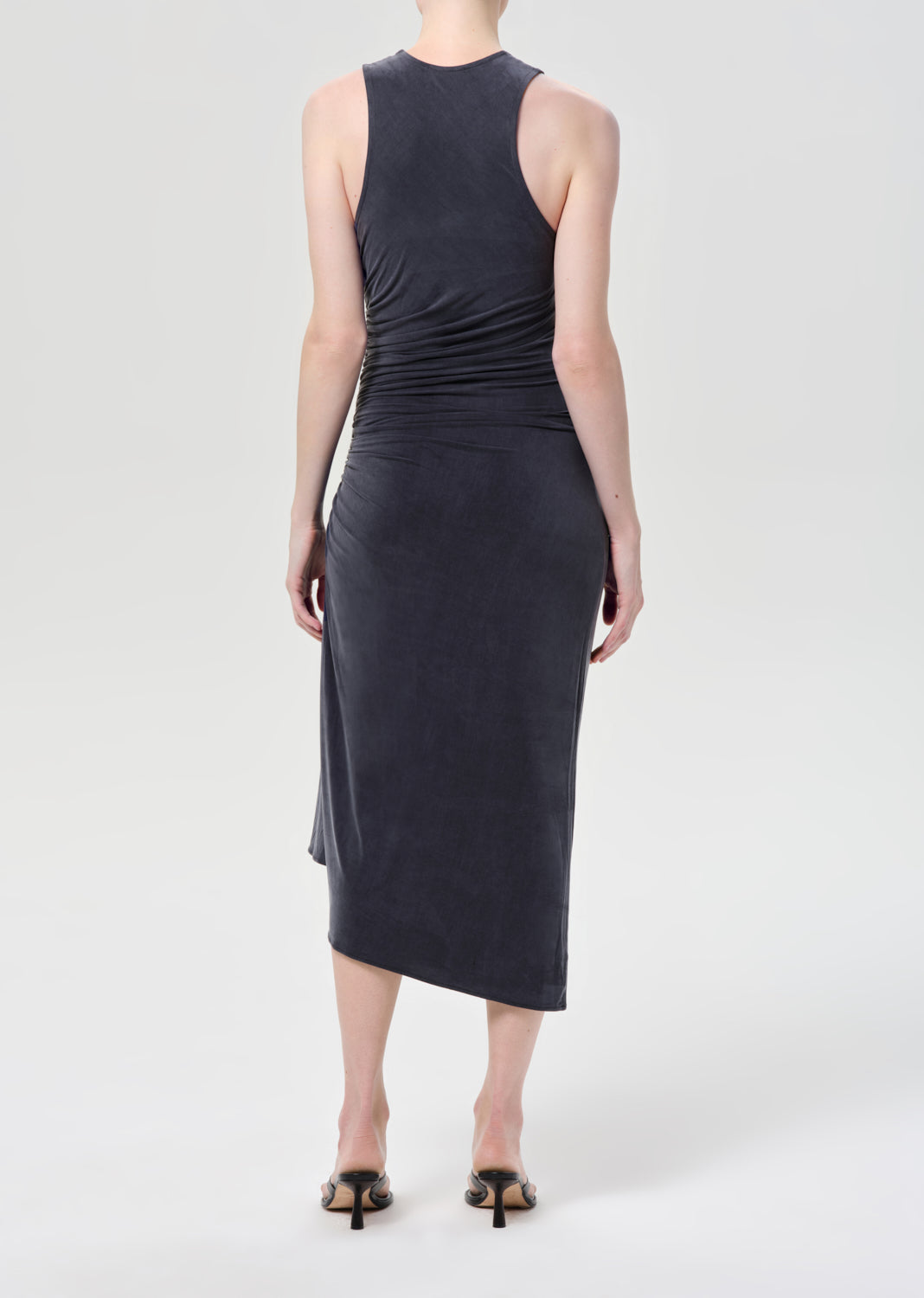 Woman wearing a sleeveless dark gray dress on a white background