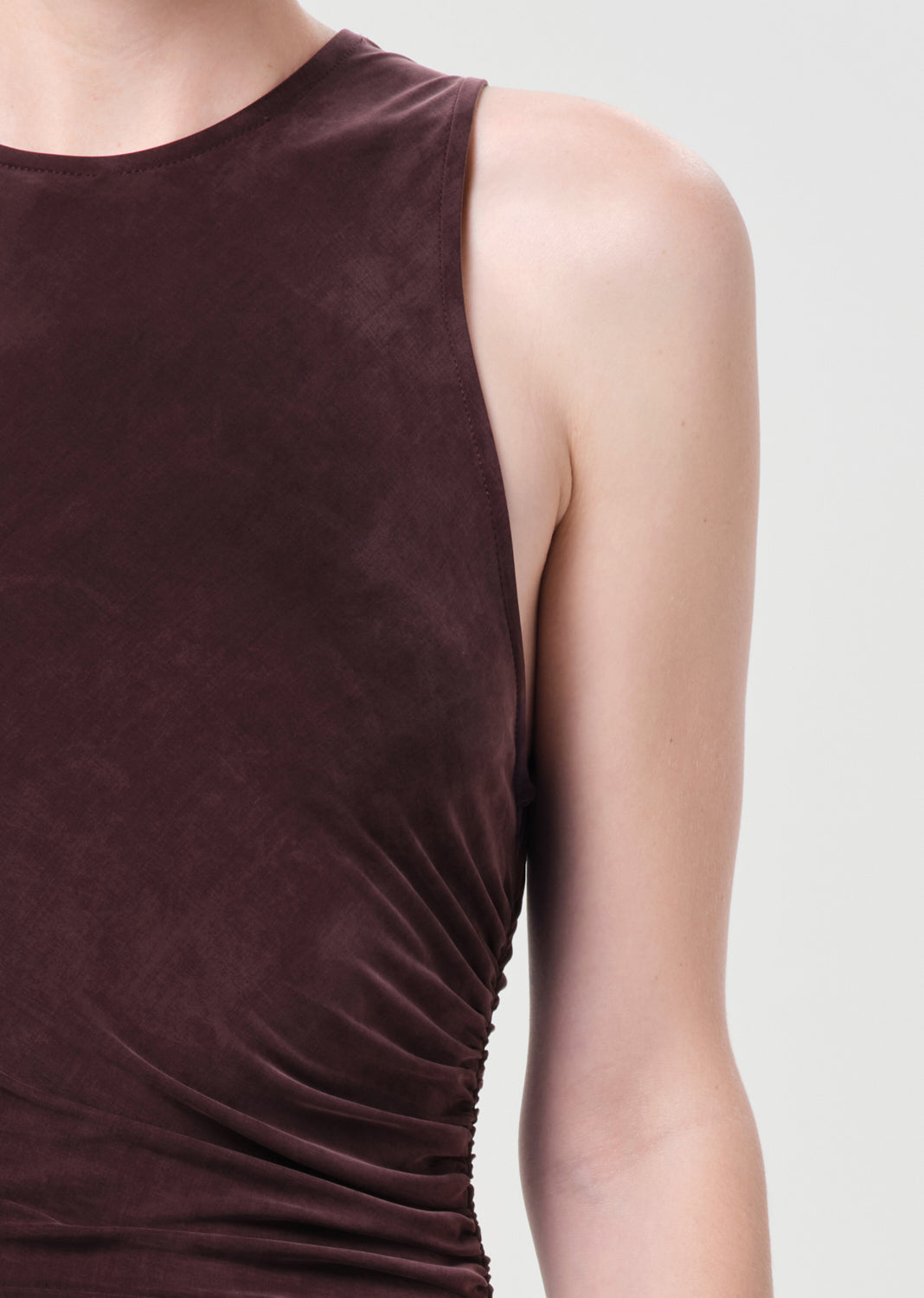 Brown sleeveless top worn by a person on a light gray background