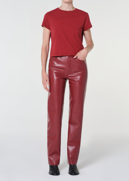 Person wearing a red t-shirt and red leather pants on a white background
