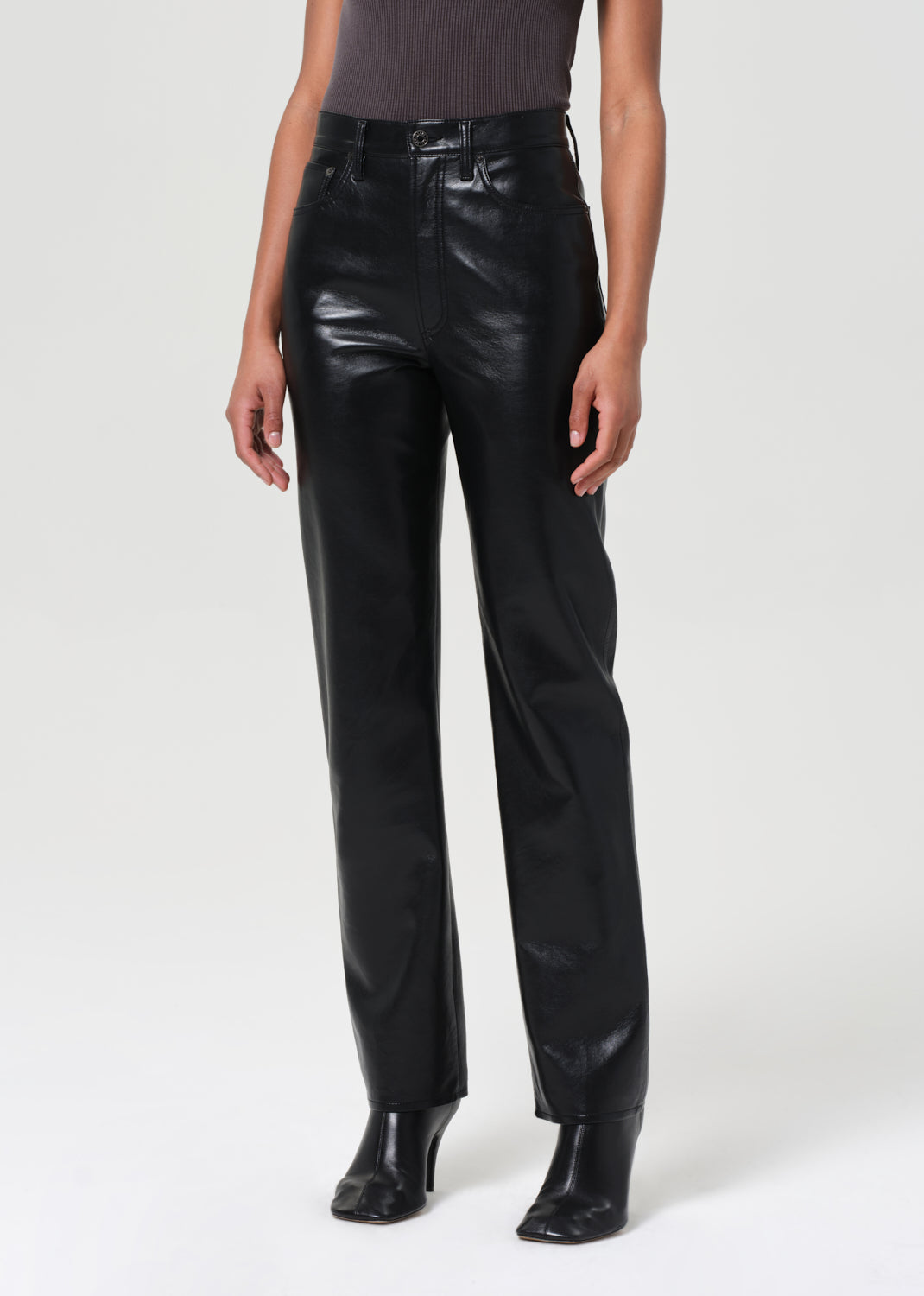 Person wearing black leather pants on a white background