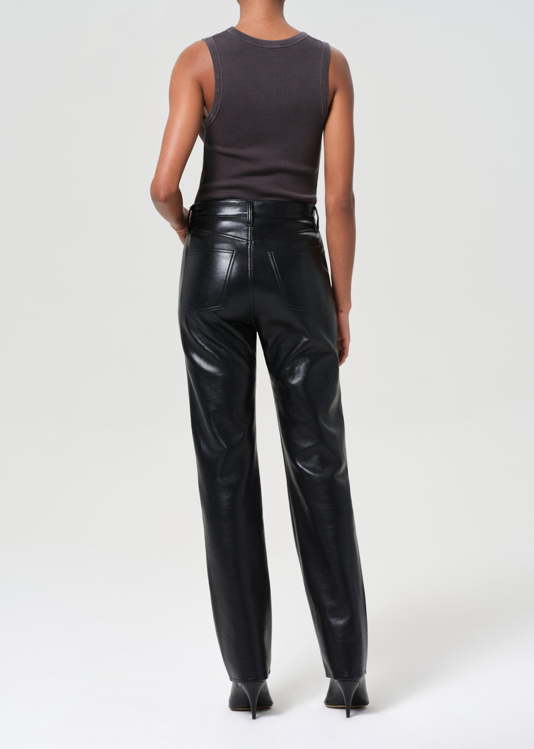 Person wearing black leather pants on a white background