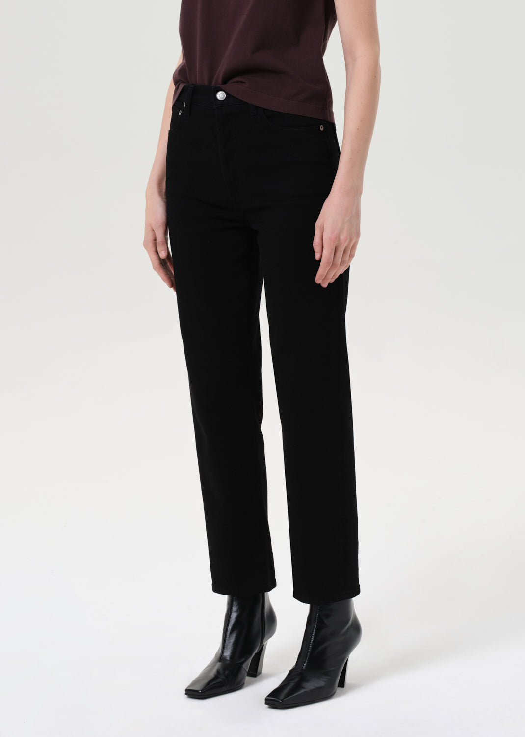 Person wearing black pants and black shoes on a white background