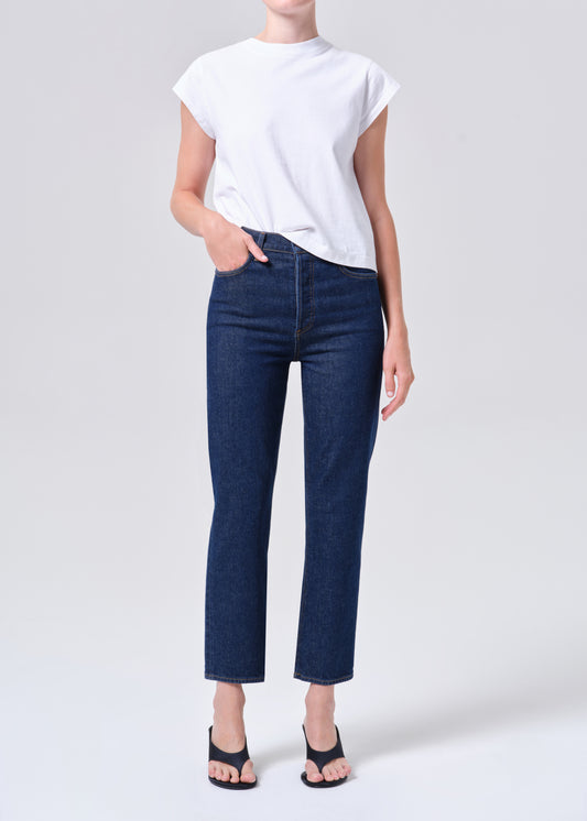 Person wearing a white t-shirt and blue jeans on a light gray background