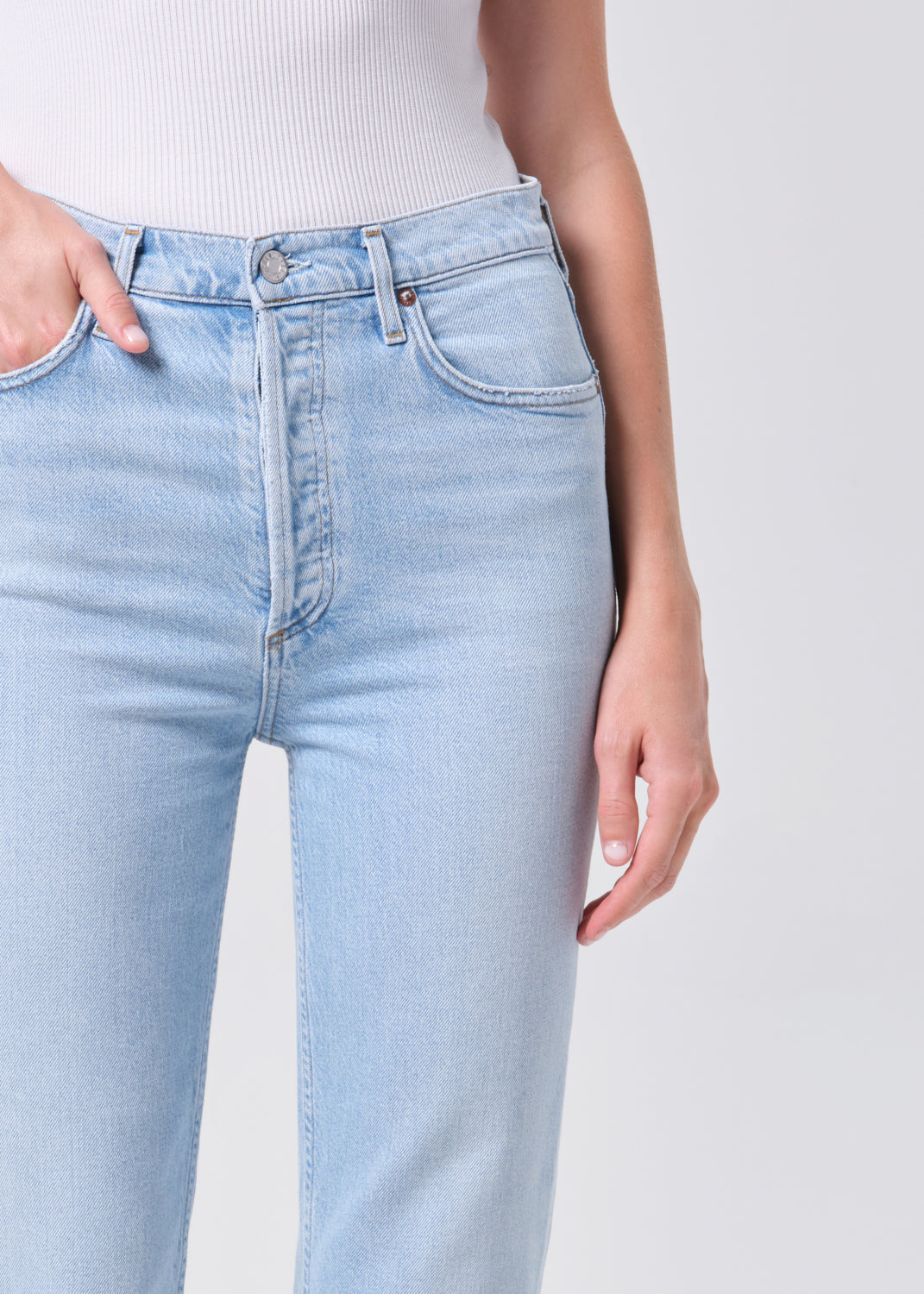 Light blue jeans worn by a person on a white background