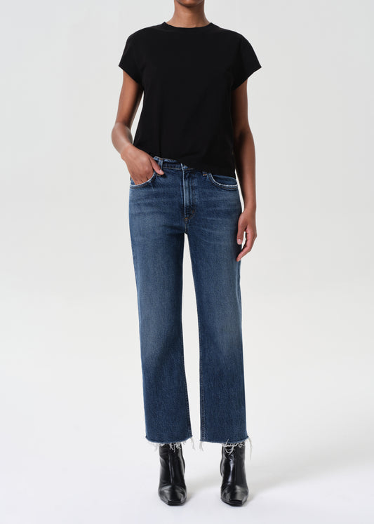 Person wearing a black t-shirt and blue jeans on a white background