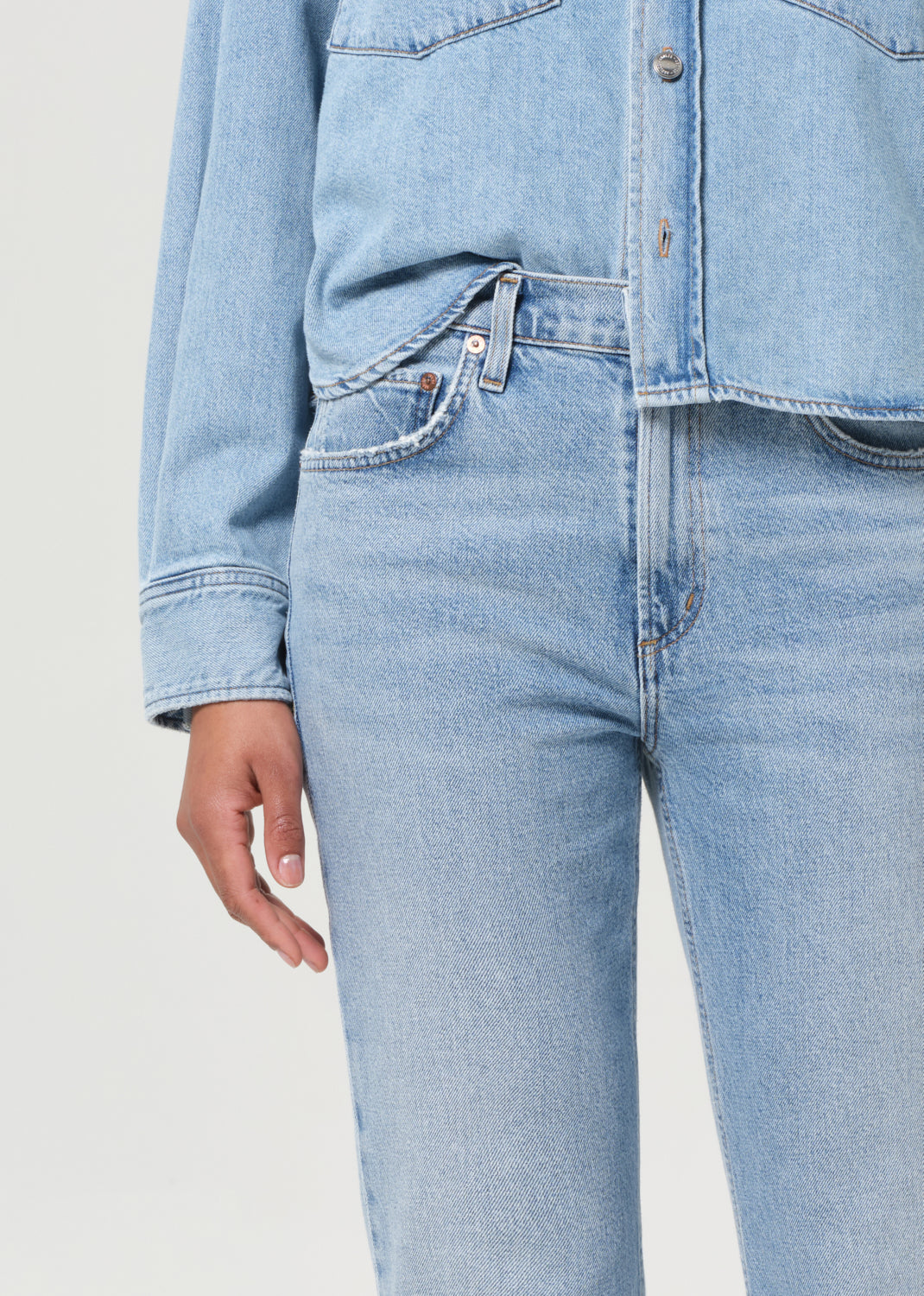 Light blue jeans worn by a person on a plain background