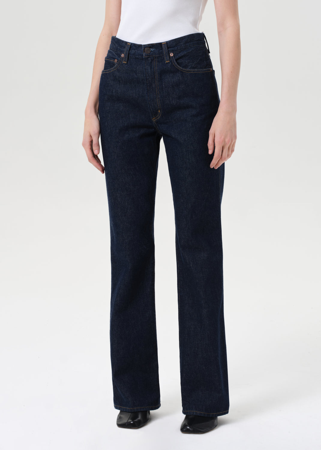 Person wearing dark blue jeans on a white background