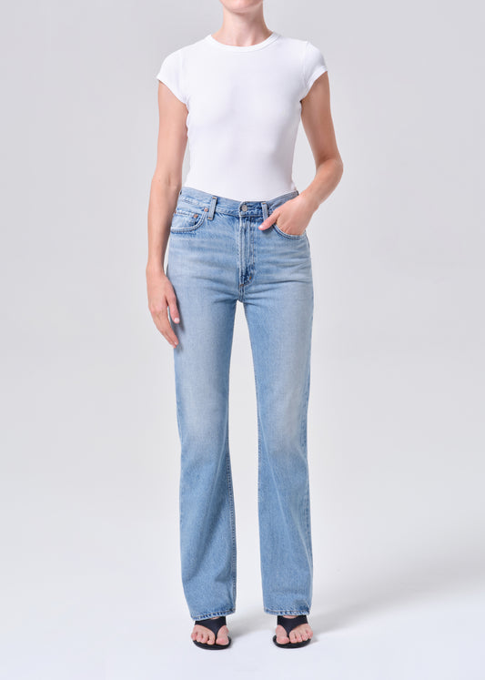 Person wearing light blue jeans and a white t-shirt on a white background