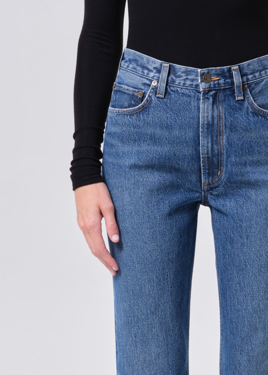 Blue jeans worn by a person on a light gray background