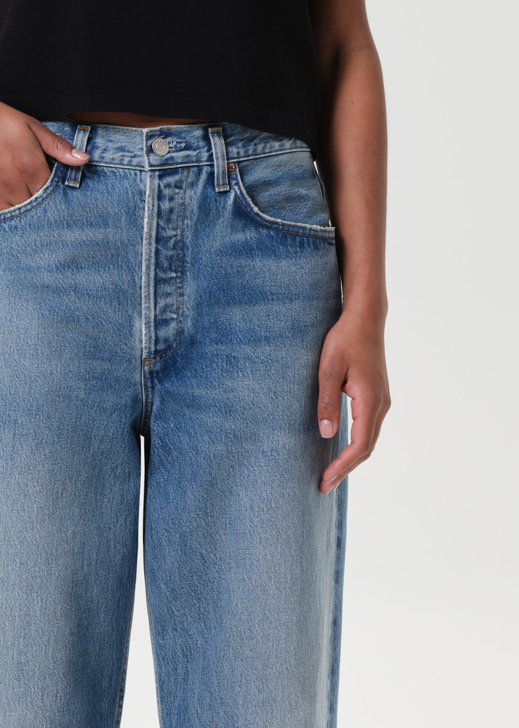 Blue jeans worn by a person on a white background