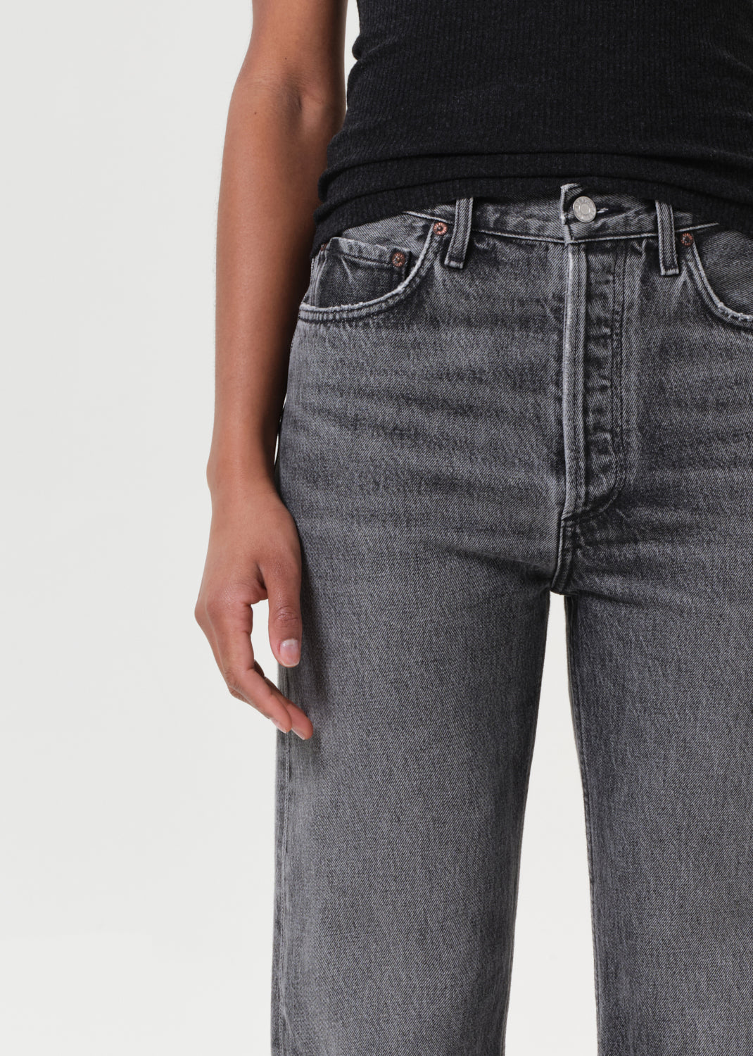 Person wearing gray jeans on a plain background
