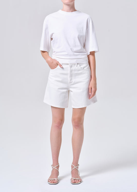 Person wearing a white t-shirt and shorts on a plain background