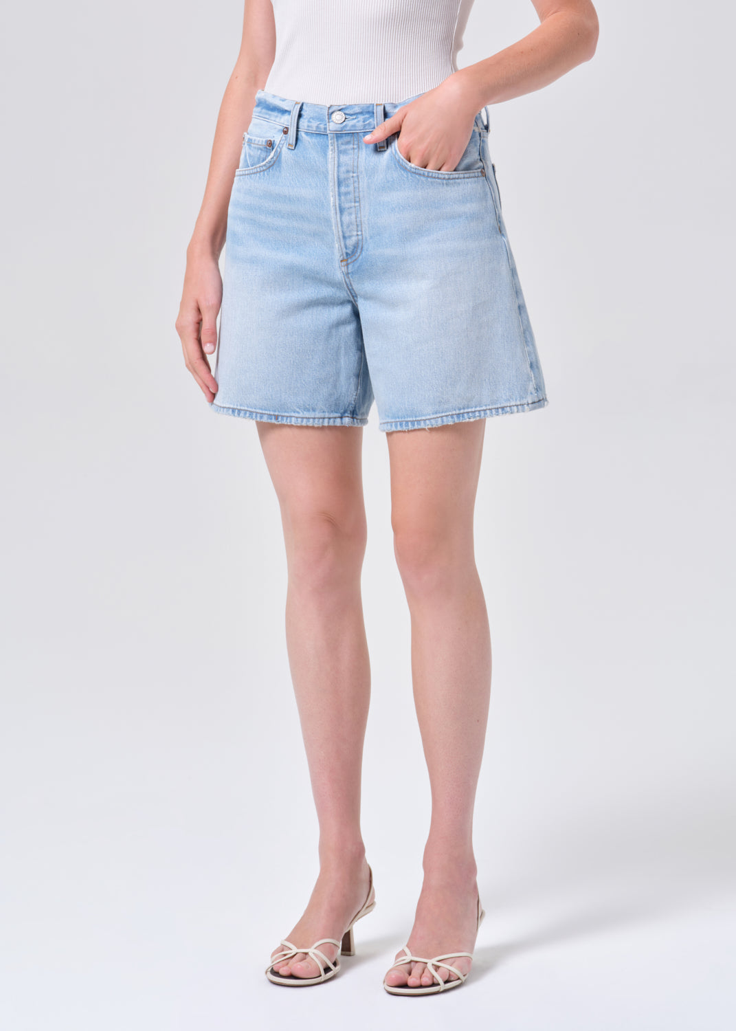 Light blue denim shorts worn by a person on a white background
