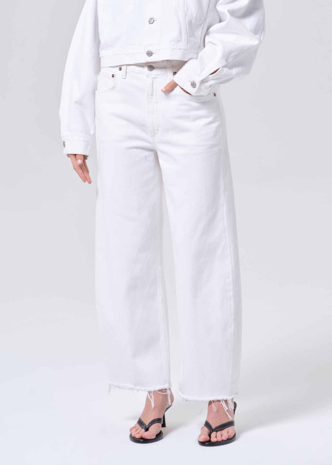 Person wearing a white outfit with a plain background