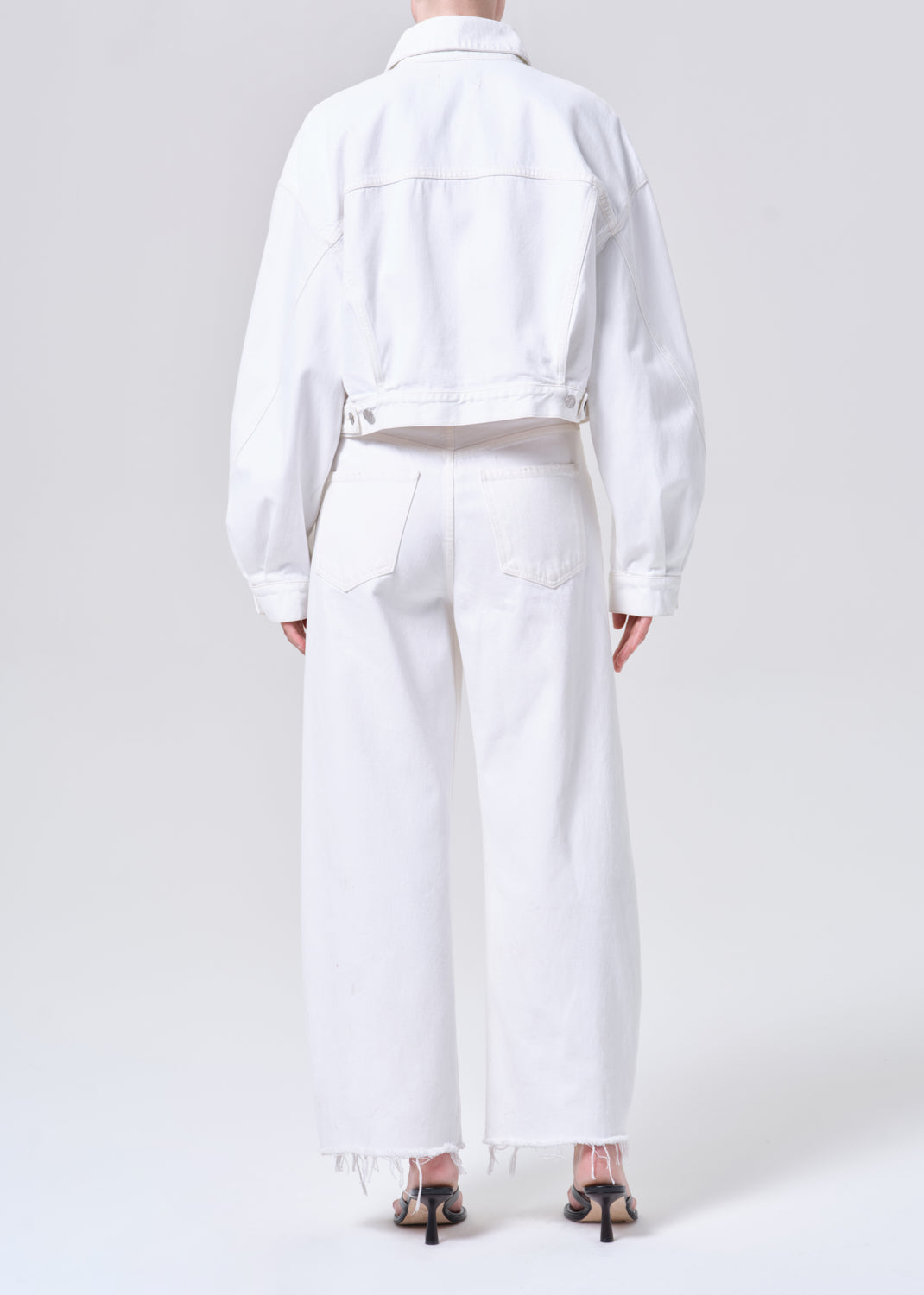 Person wearing a white outfit on a plain background