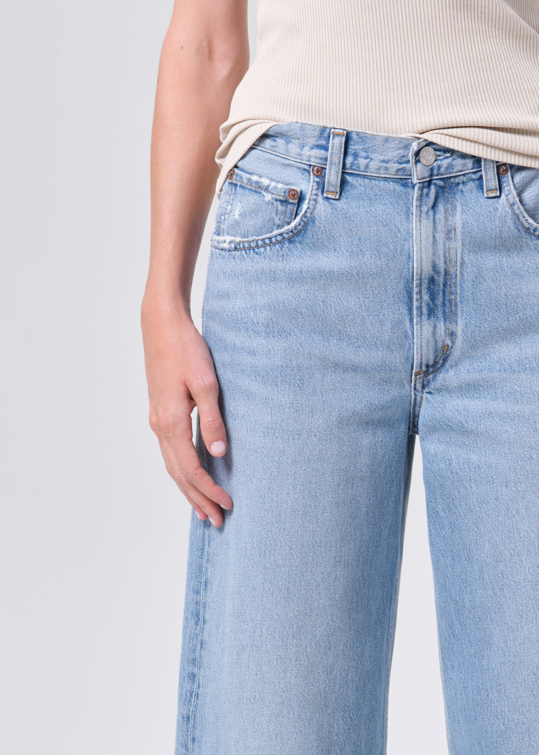 Light blue jeans worn by a person on a light gray background