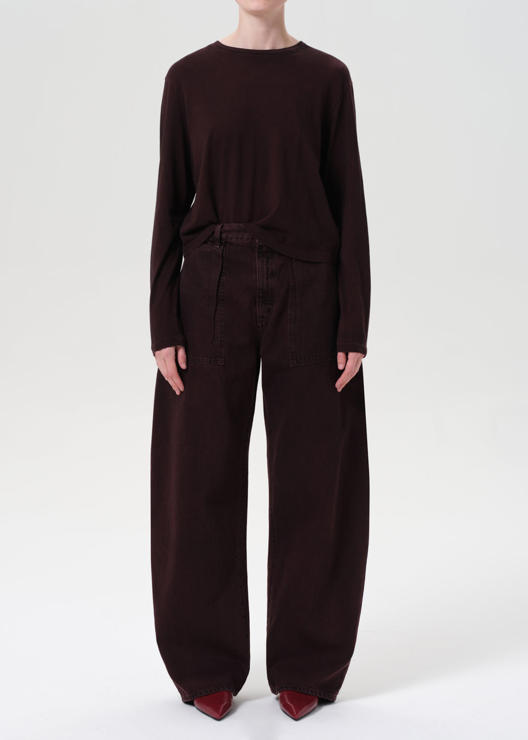 Person wearing a dark brown outfit on a white background