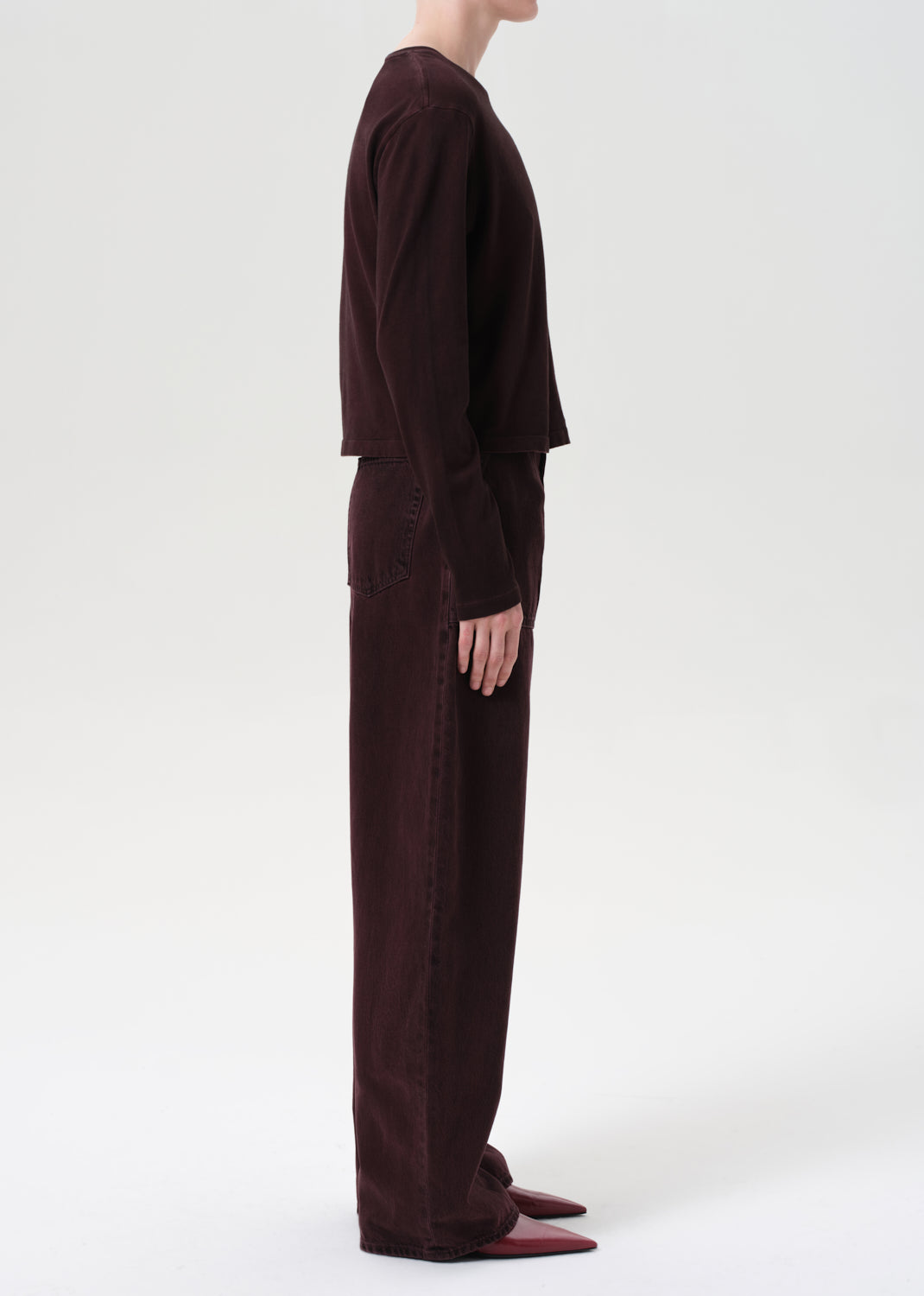 Person wearing a dark brown outfit on a white background