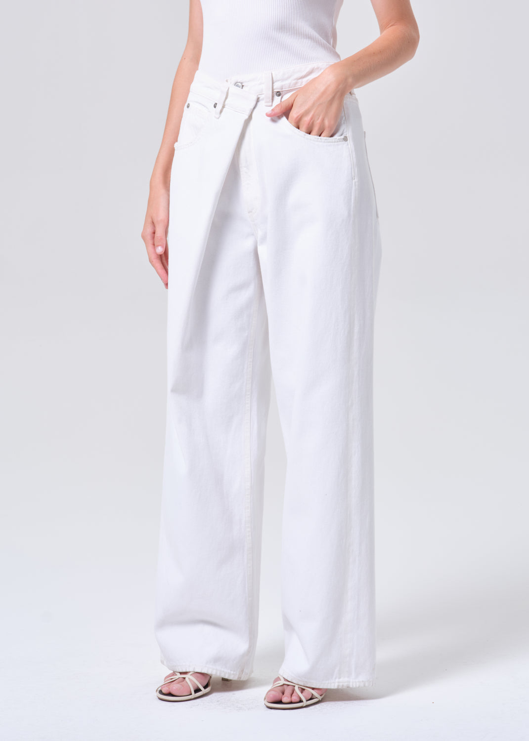 Person wearing white wide-leg pants on a plain background