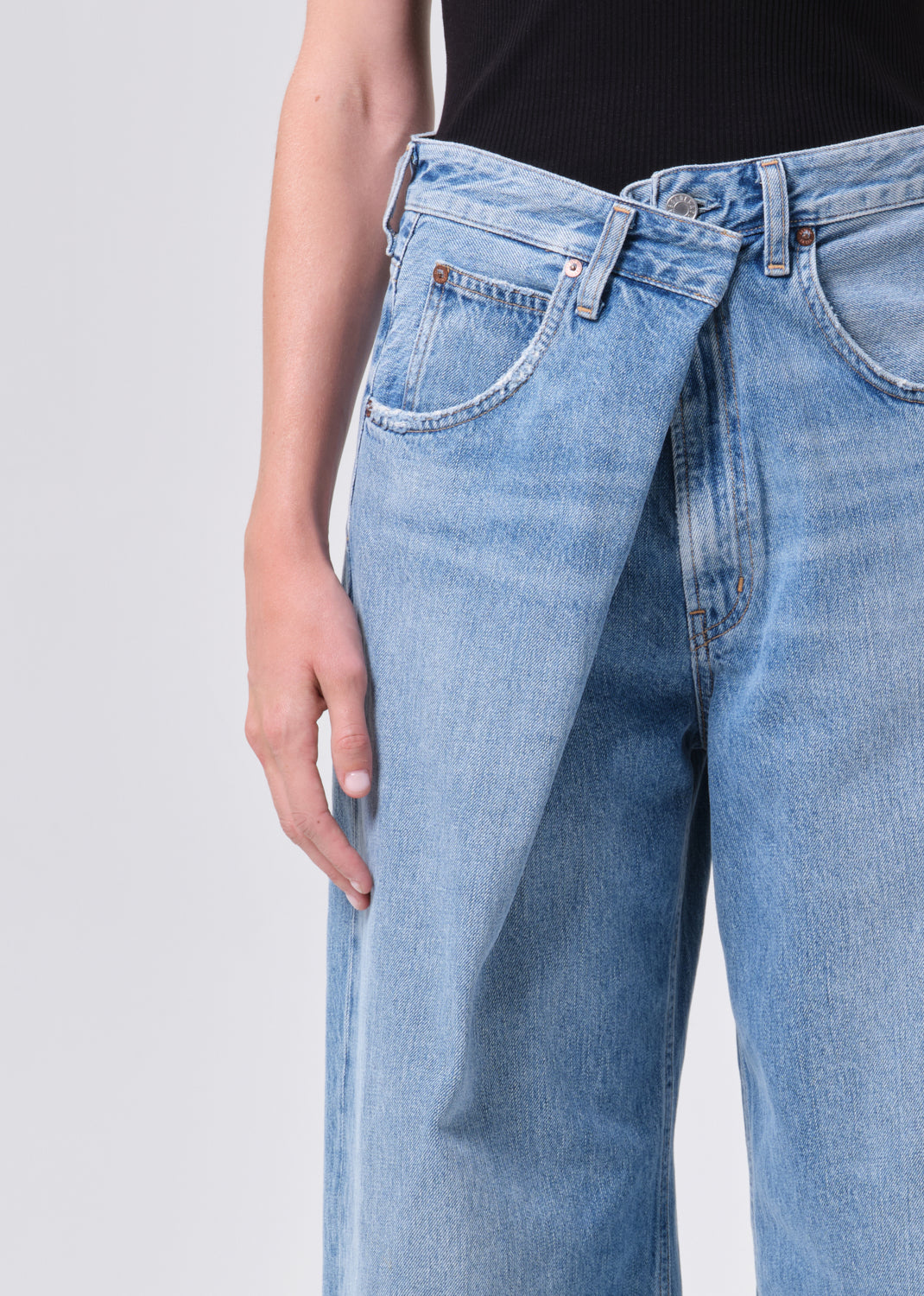 Light blue jeans worn by a person on a light gray background