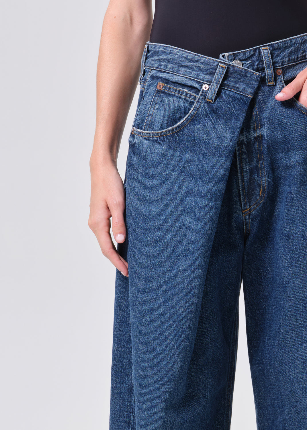 Blue jeans worn by a person on a light gray background