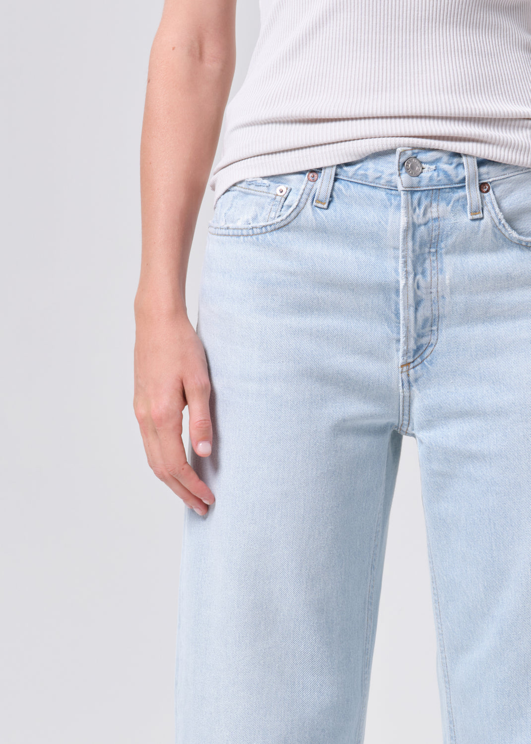 Light blue jeans worn by a person on a plain background