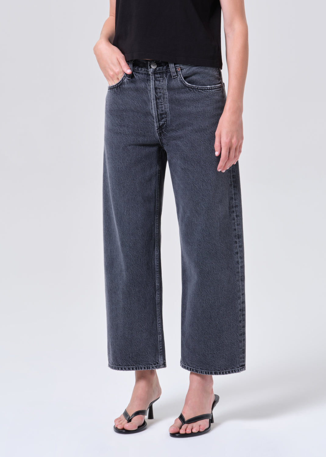 Person wearing dark blue jeans on a white background