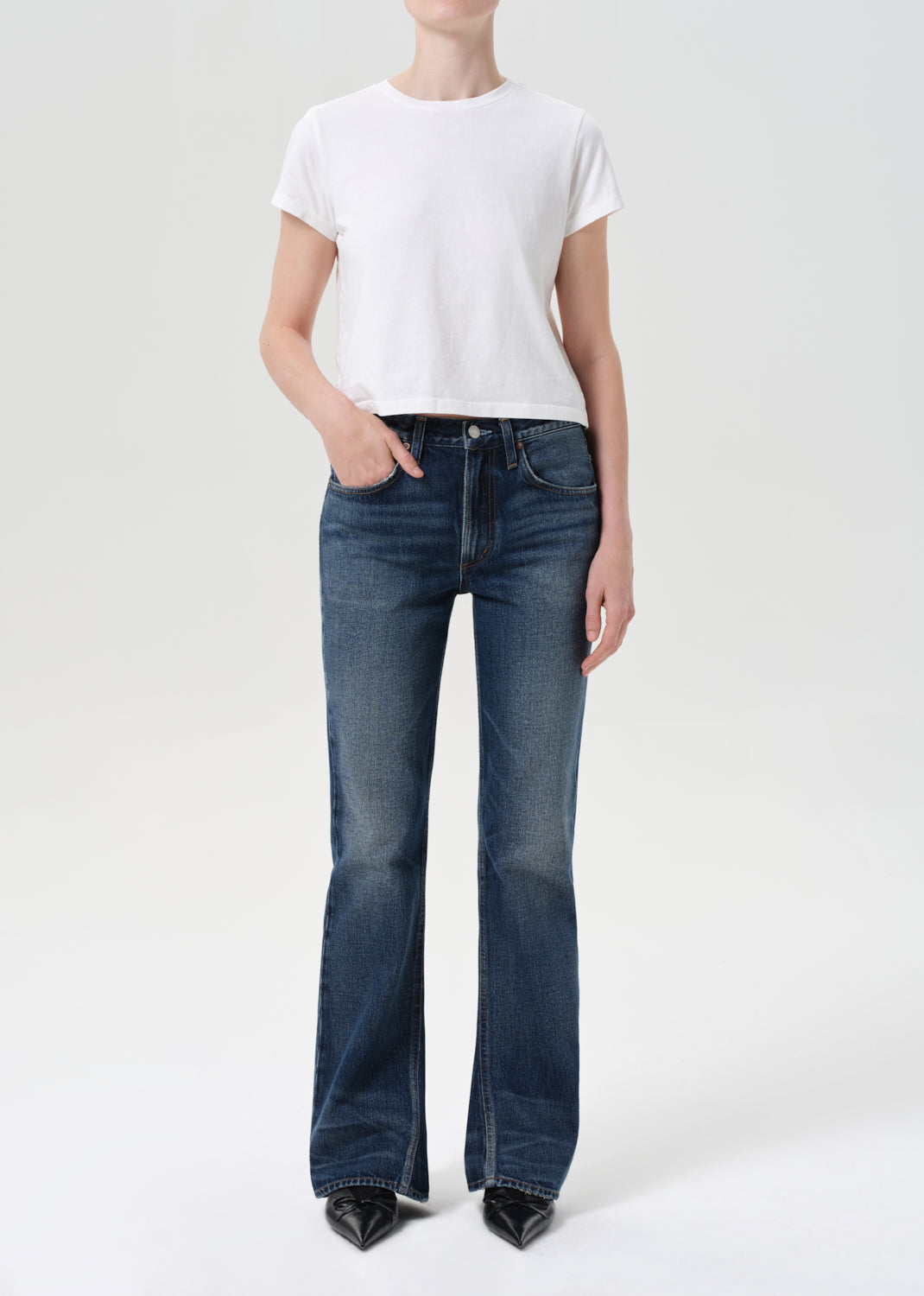 Person wearing a white t-shirt and blue jeans on a white background