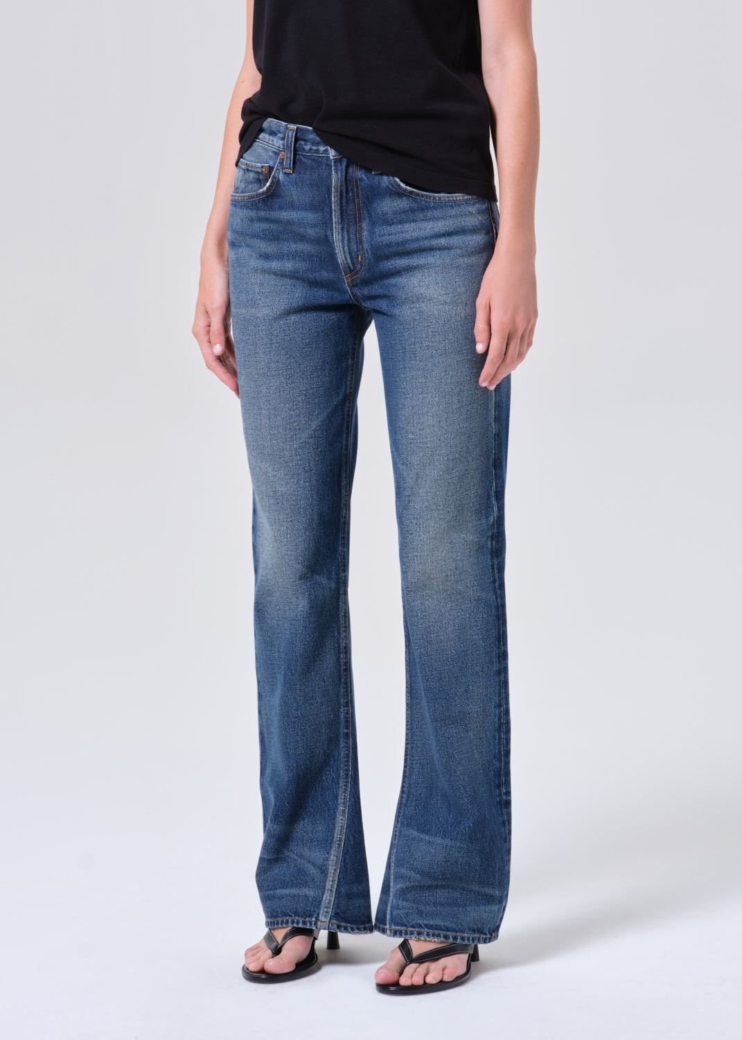 Person wearing blue jeans on a white background