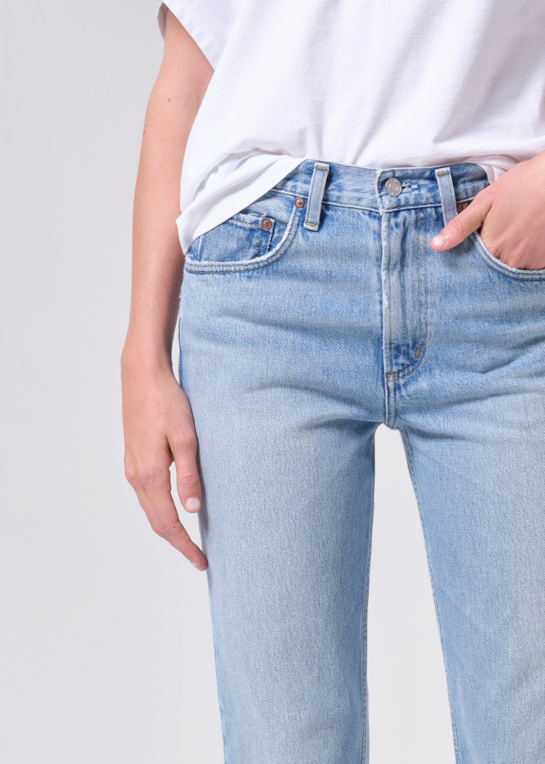 Light blue jeans worn by a person on a plain background