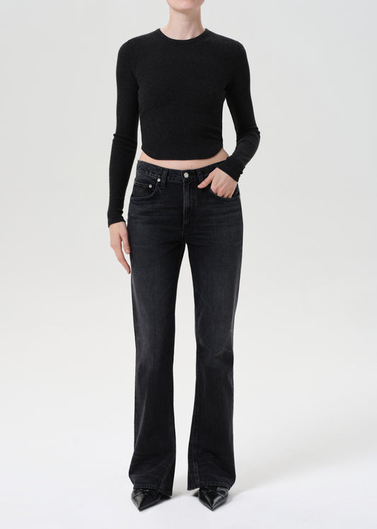 Person wearing a black long-sleeve top and black jeans on a white background