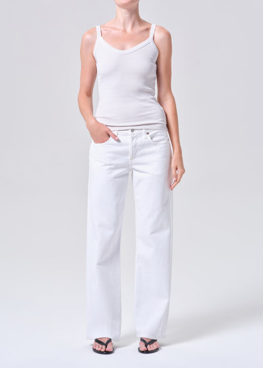 Person wearing a white tank top and white pants on a plain background