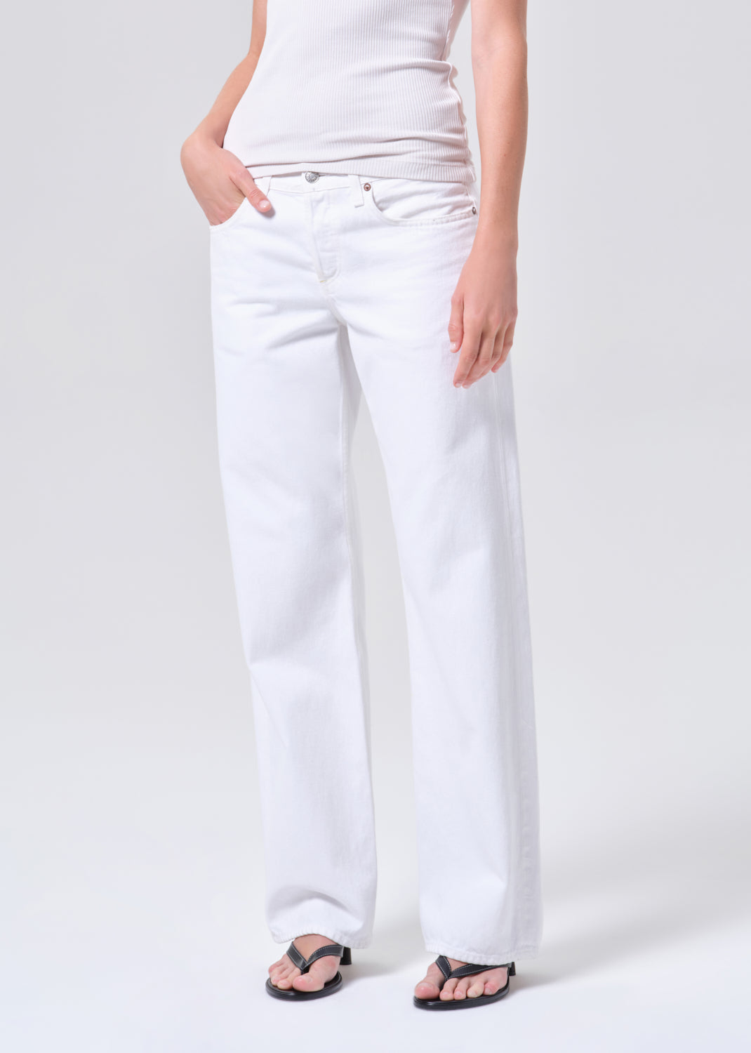 Person wearing white pants on a plain background