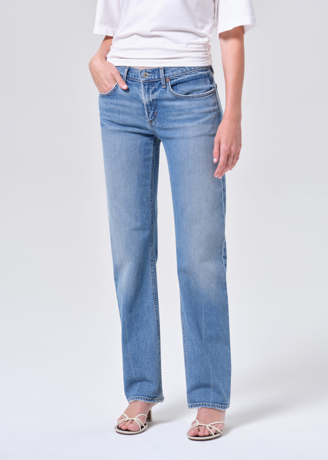 Person wearing light blue jeans on a white background