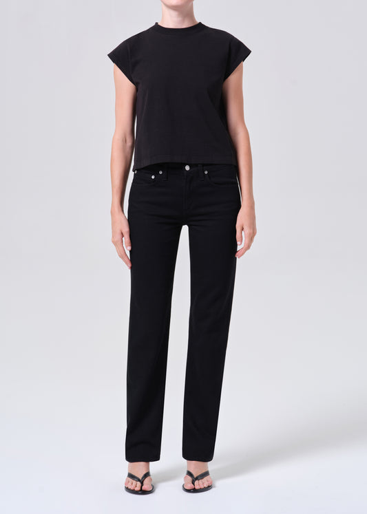 Person wearing a black sleeveless top and black pants on a white background